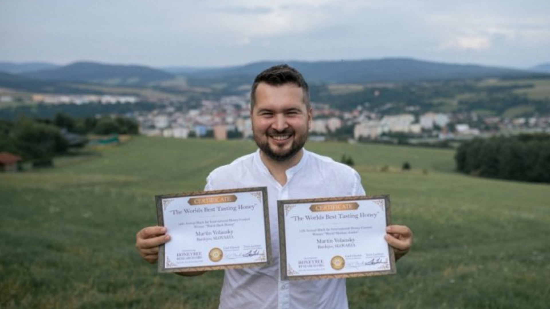 Na fotke je majiteľ firmy Medár.sk na výrobu medu s jeho oceneniami.