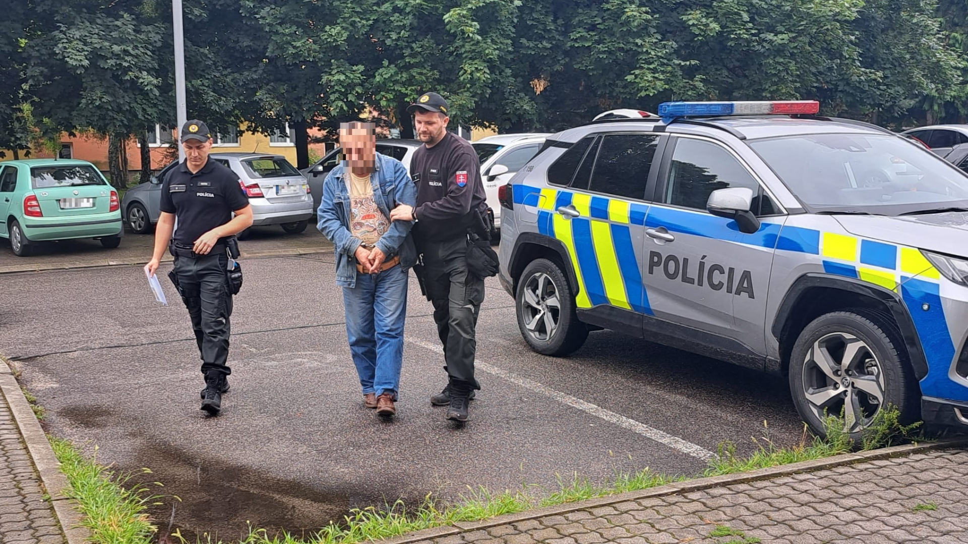 Policajti odvádzajú páchateľa ktorý ma na svedomí útok autom a kladivom