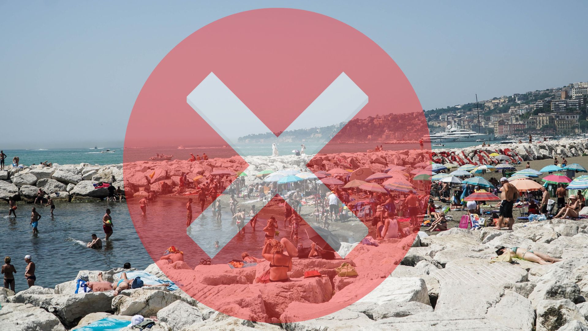 Množstvo dovolenkárov na pláži. Fotografia s červenýk krížikom