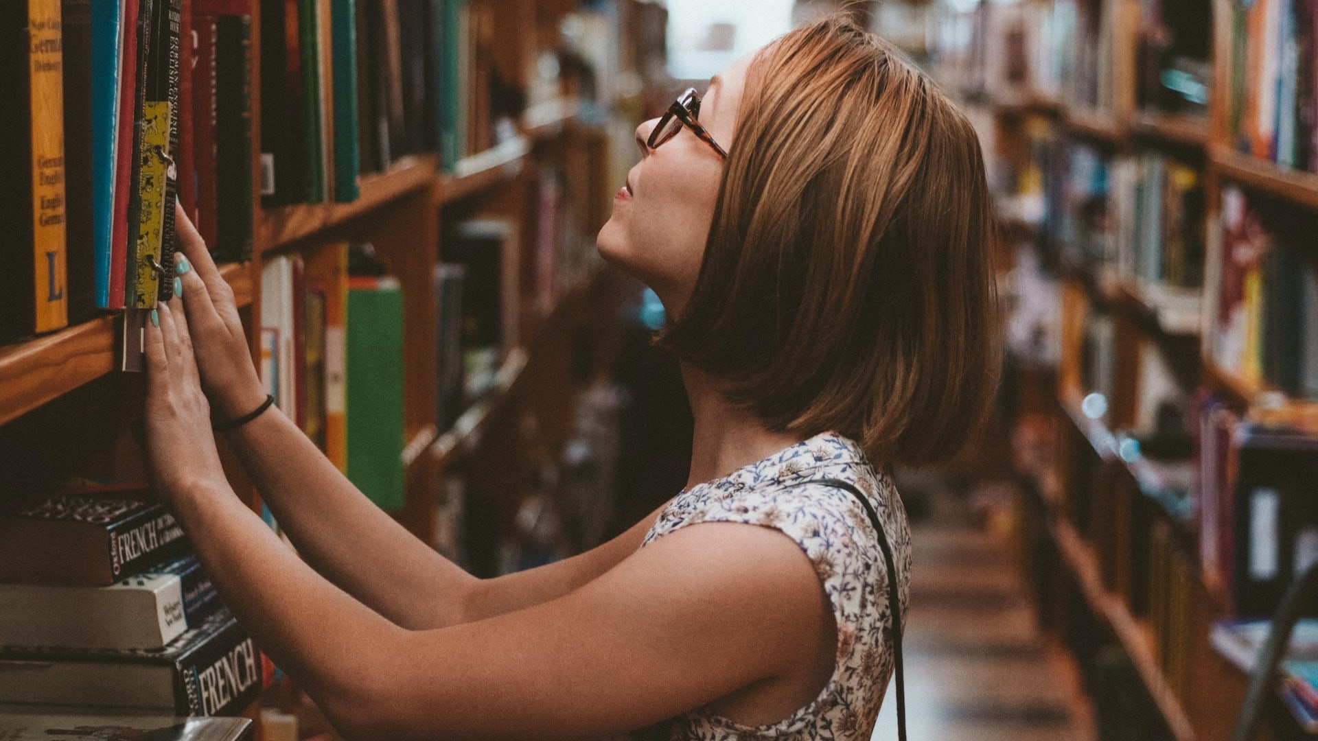 Žena si vyberá knihy v knižnici