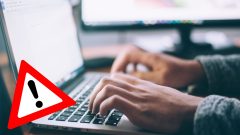 Na snímke človek píšuci na počítači.