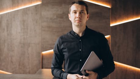 na snímke je muž, ktorý drží tablet