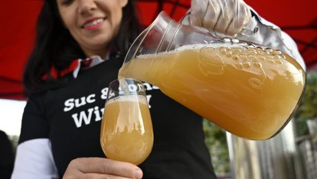 Na snímke je žena nalievajúca burčiak.