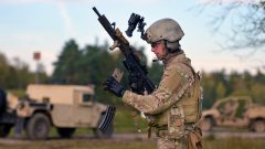 Vojak drží pušku M4 a prebíja zásobníky