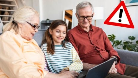 Starí rodičia s dievčatkom pozerajú do tabletu.