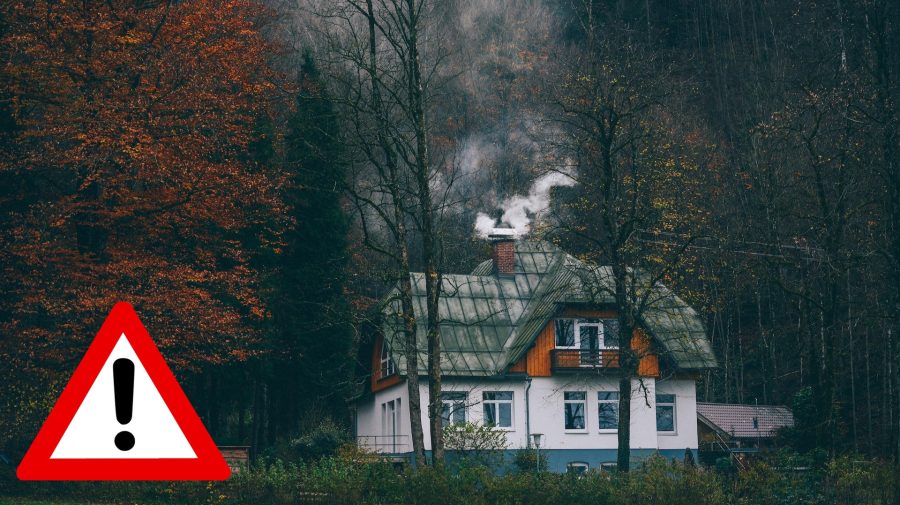 Dom v lese, z ktorého komínu sa dymí.