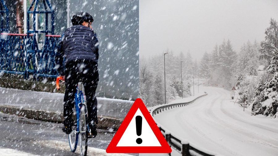 Muž na bicykli idę po ceste, keď sneží a zasnežená cesta.