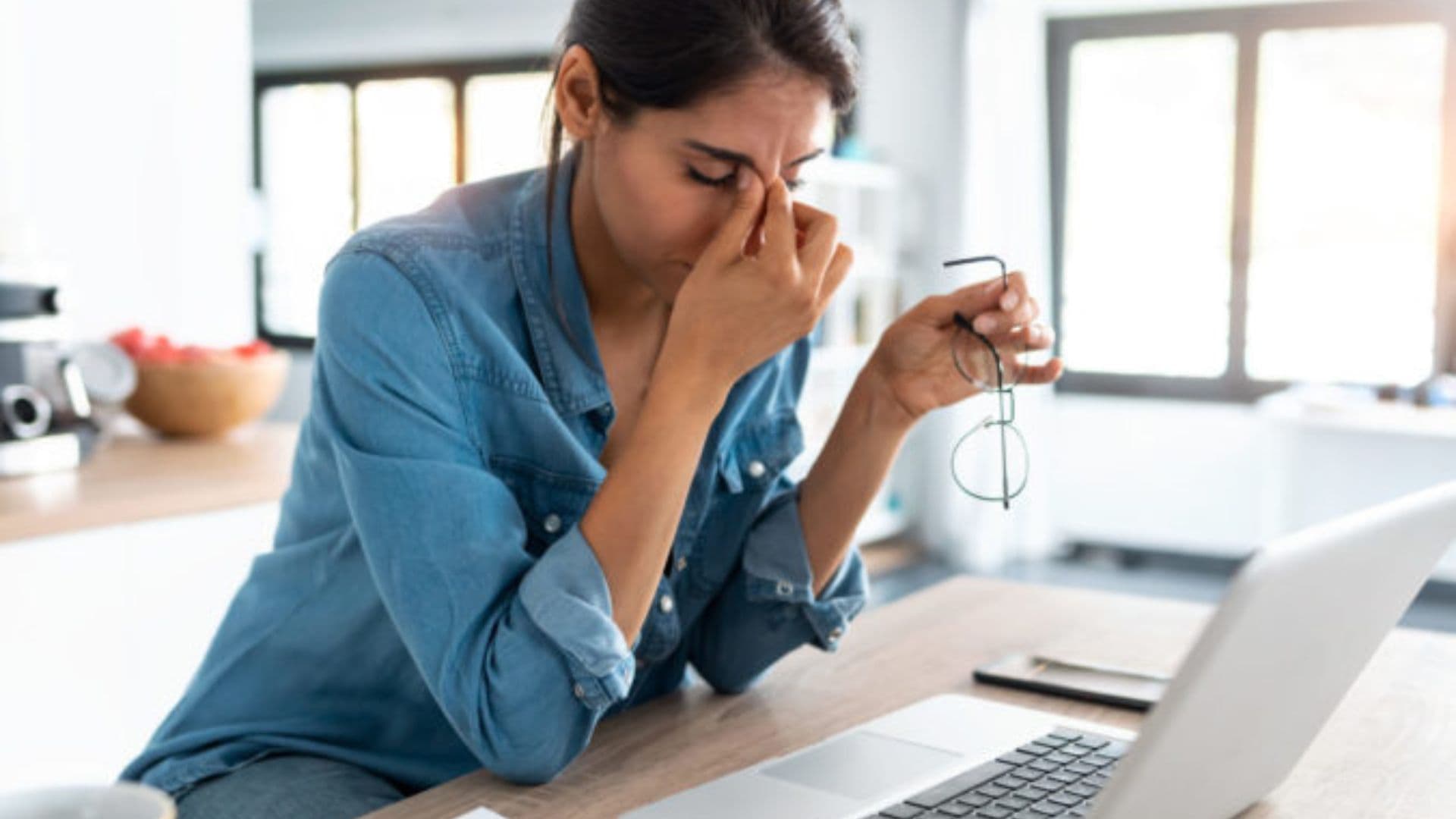 Vyčerpaná žena za notebookom