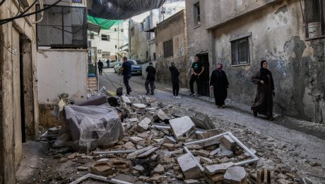 Palestínčania prechádzajú okolo zničenej oblasti