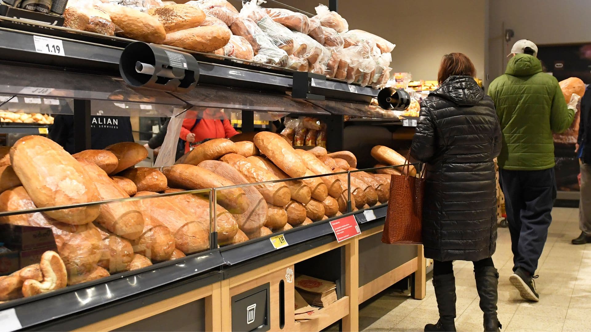 Ľudia v potravinách pri pečive.