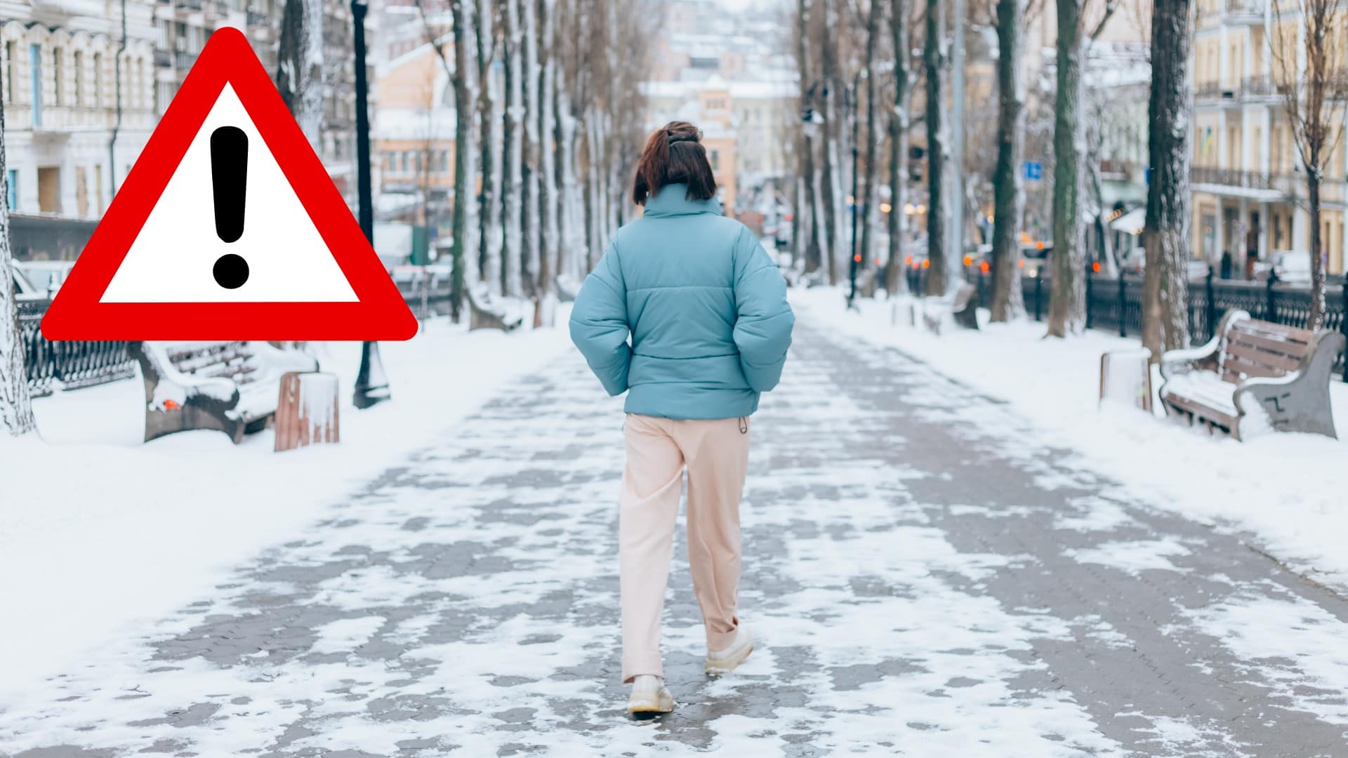 Žena kráča po zasneženom chodníku.