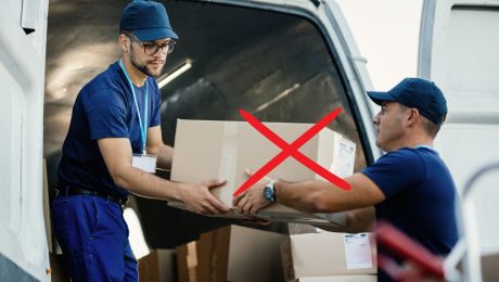 Kuriér podáva balík svojmu kolegovi.