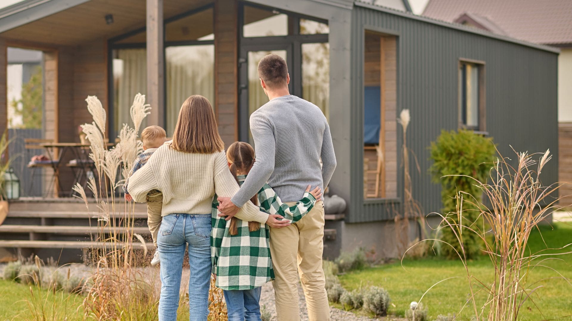 Rodinka stojí pred domom.
