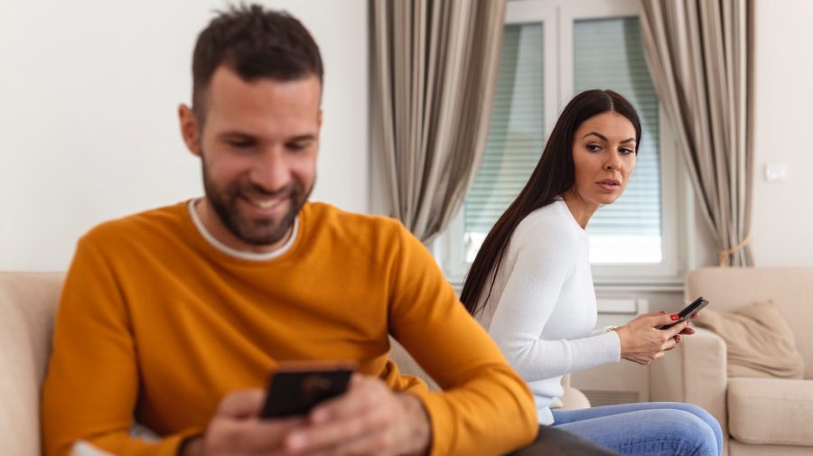 muž a žena v obývačke s mobilom v ruke