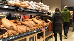 Ľudia v obchode nakupujú chlieb a pečivo