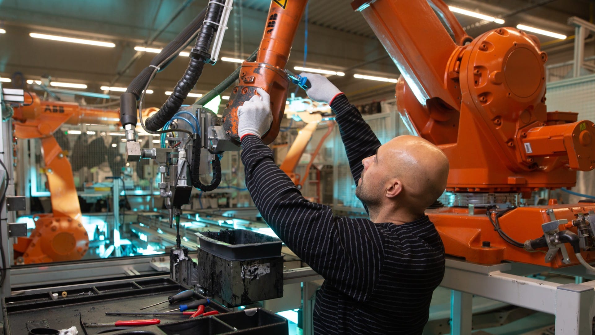 Na snímke je človek pri výrobe auta