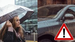 Žena s dáždnikom v ruke a špinavé auto.