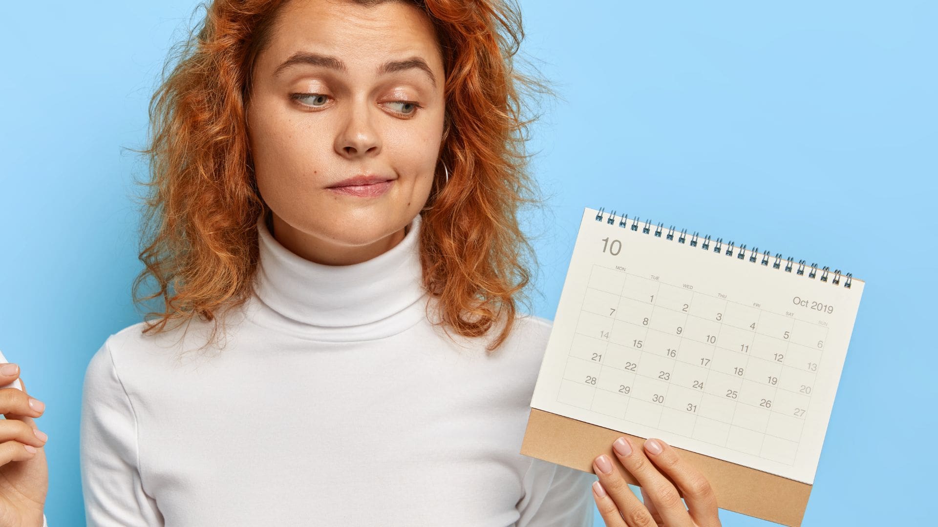 Žena drží kalendár v ruke.