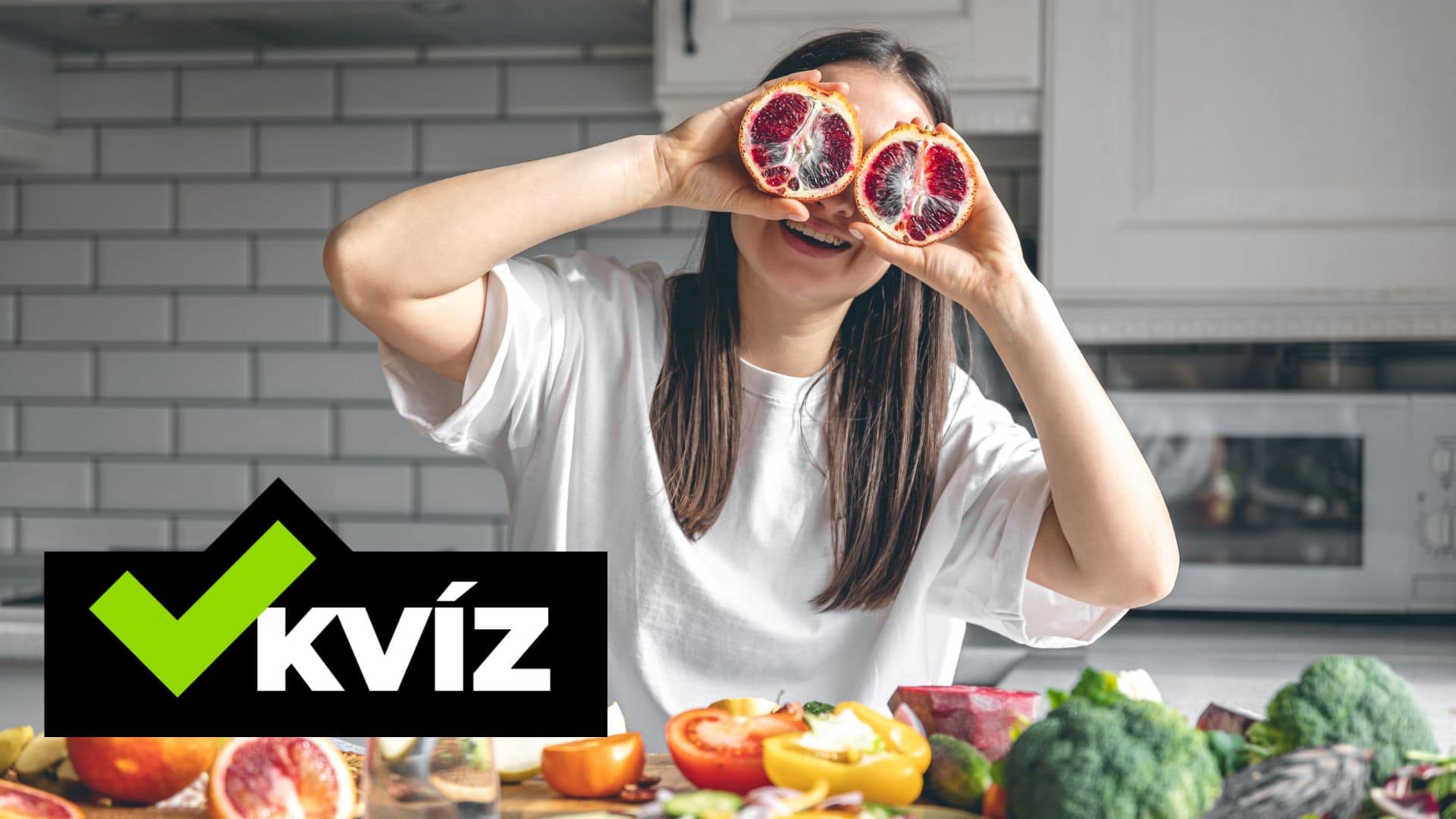 Žena si drží grep pri očiach a stôl plný zeleniny a ovocia.