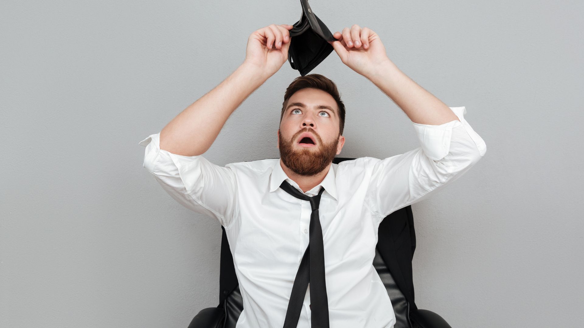 Muž pozerá do prázdnej peňaženky.