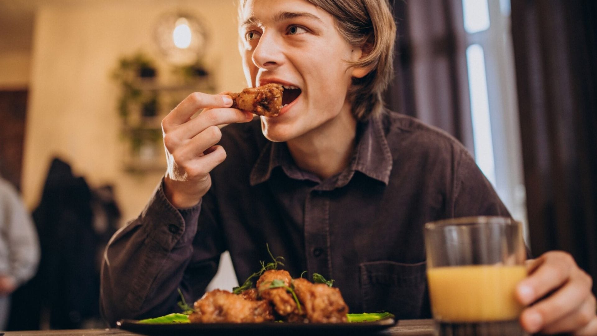 Muž konzumuje jedlo v reštaurácii.