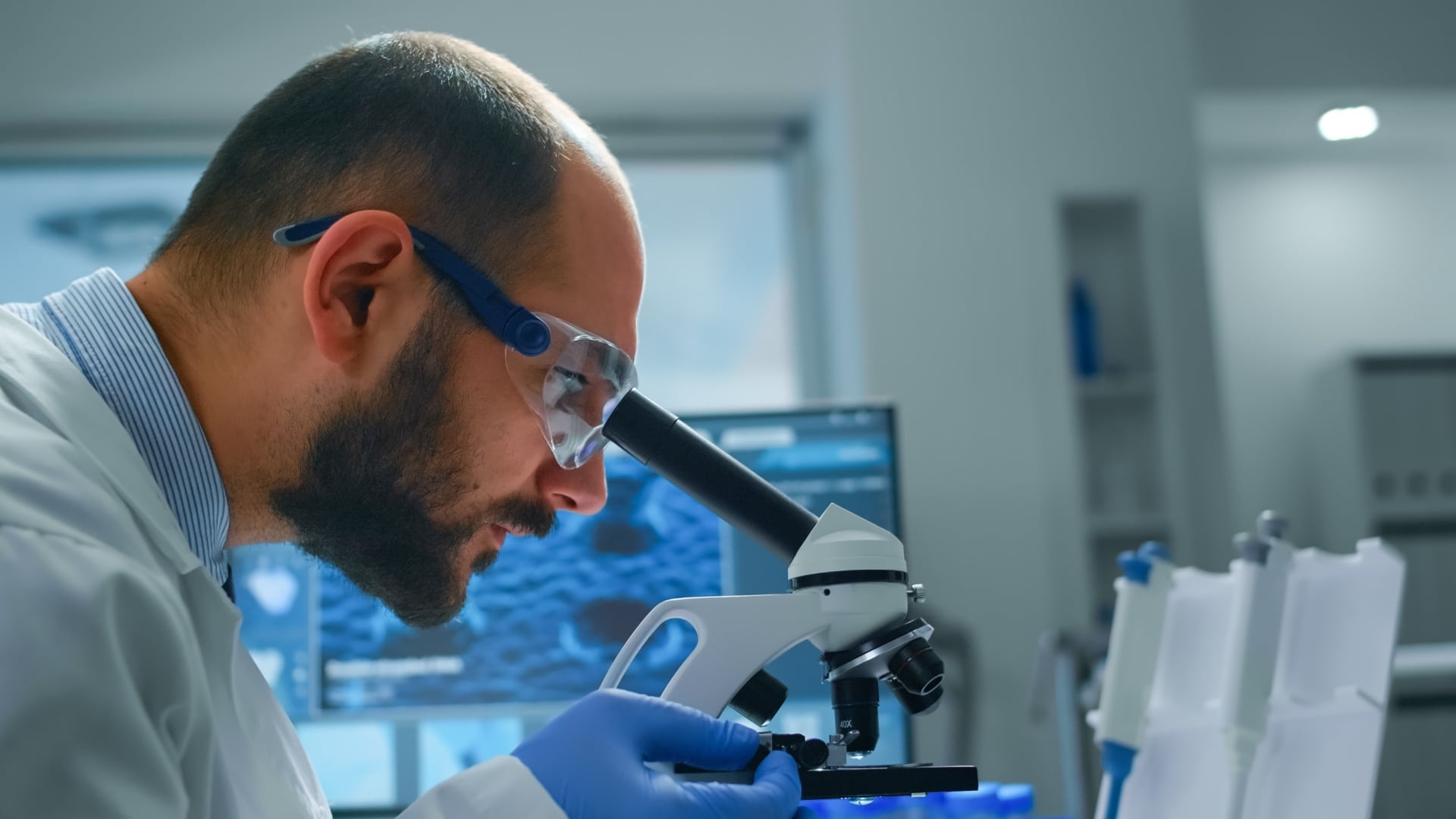 Vedec pozerá do mikroskopu.