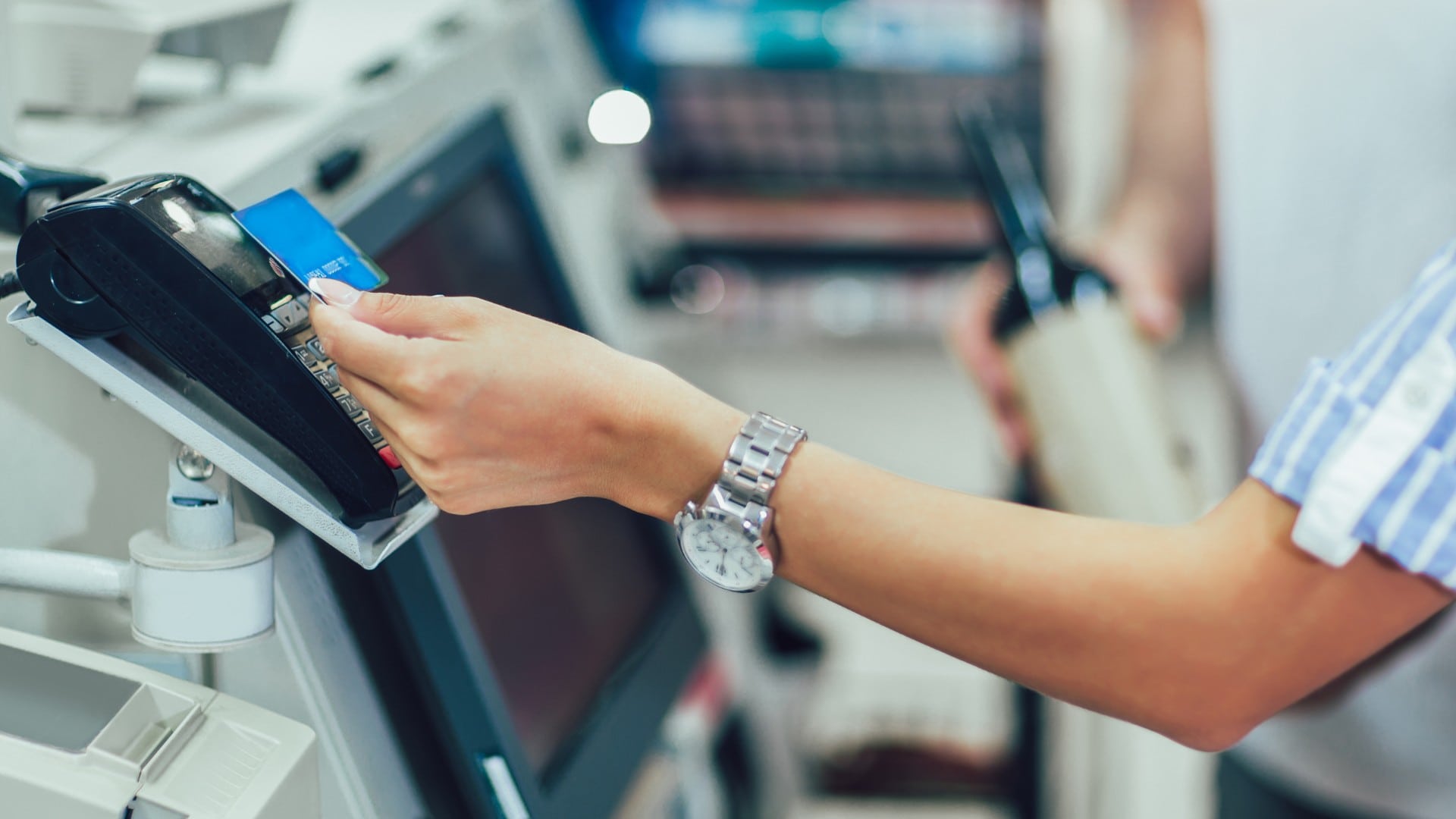 na snímke je žena platiaca bezkontaktne kartou