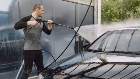 Muž umýva auto v umývarke.