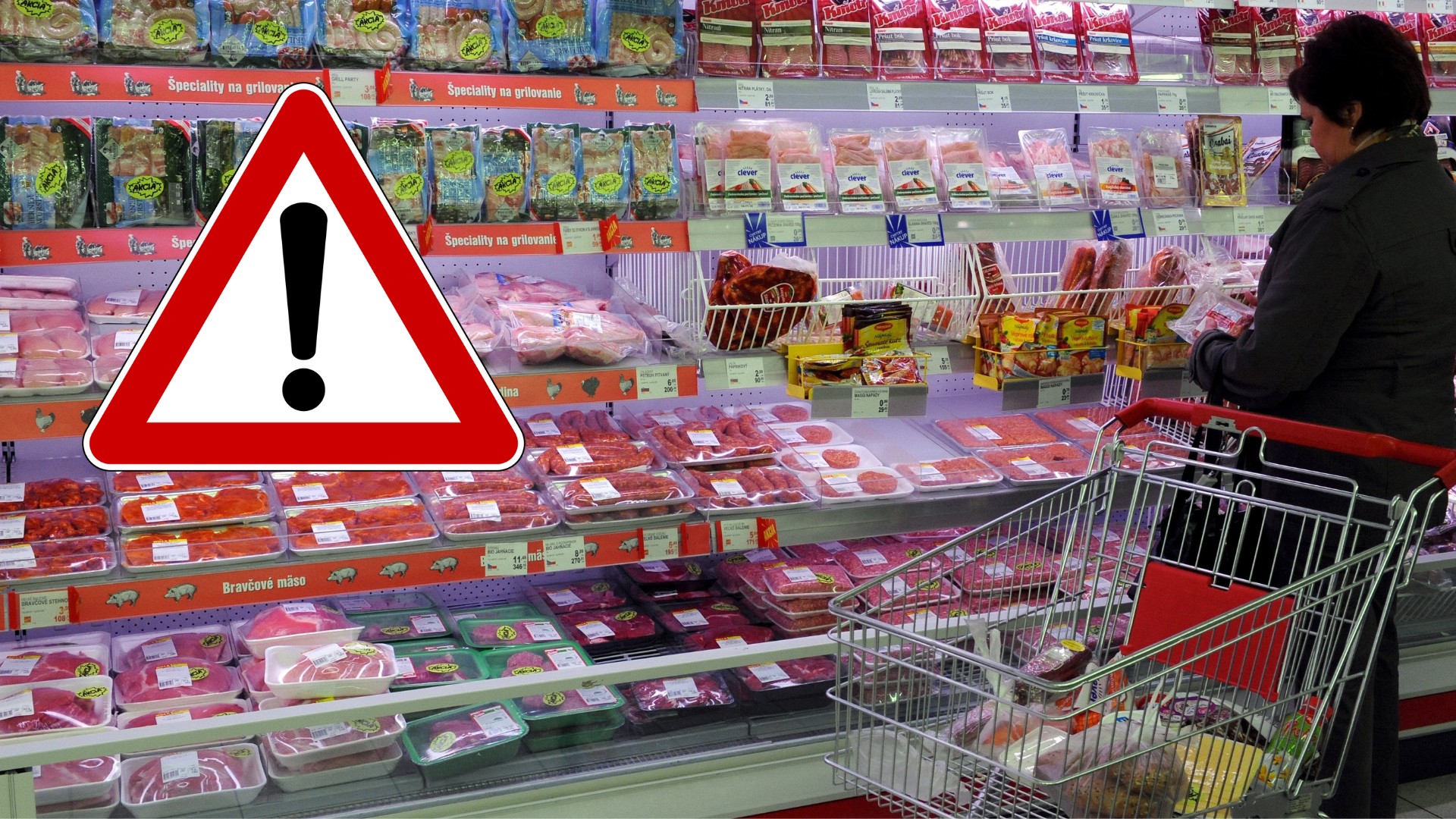 Žena s nákupným košíkom stojí pri regáli s mäsovými výrobkami.