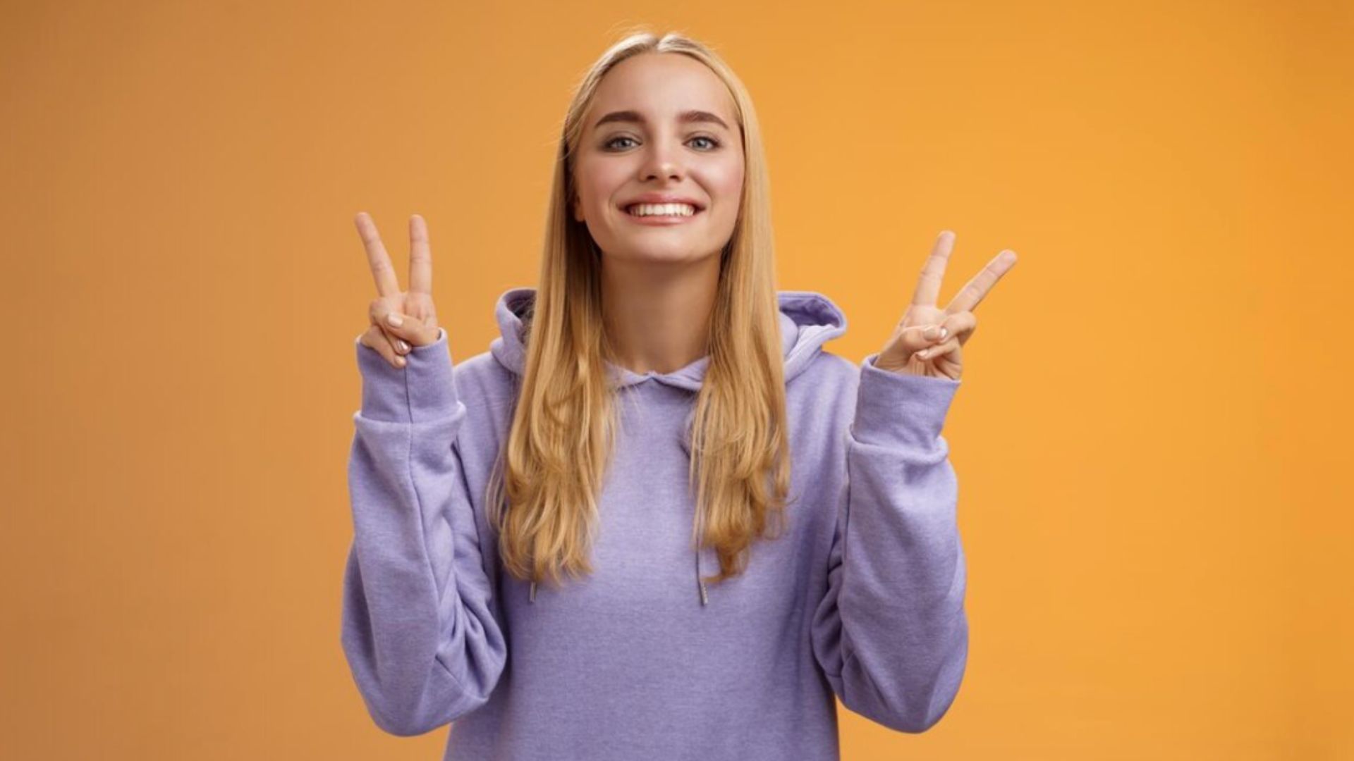 Žena ukazuje znak mieru.