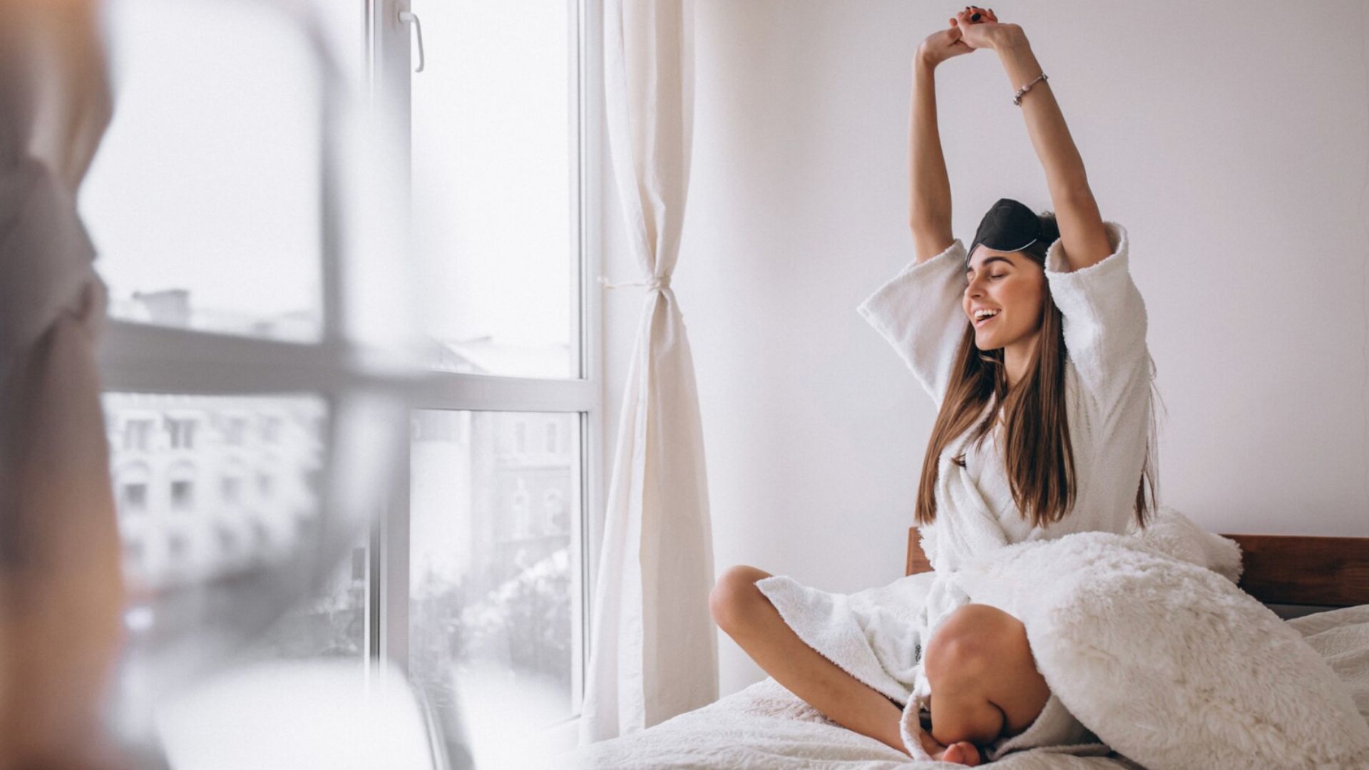 Žena sa naťahuje v posteli.