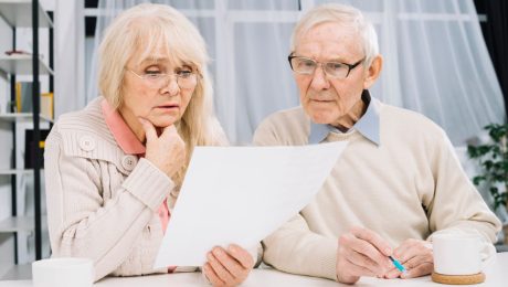 Staršia žena a muž hľadia do papiera.