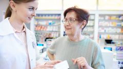 Farmaceutka ukazuje žene lieky.