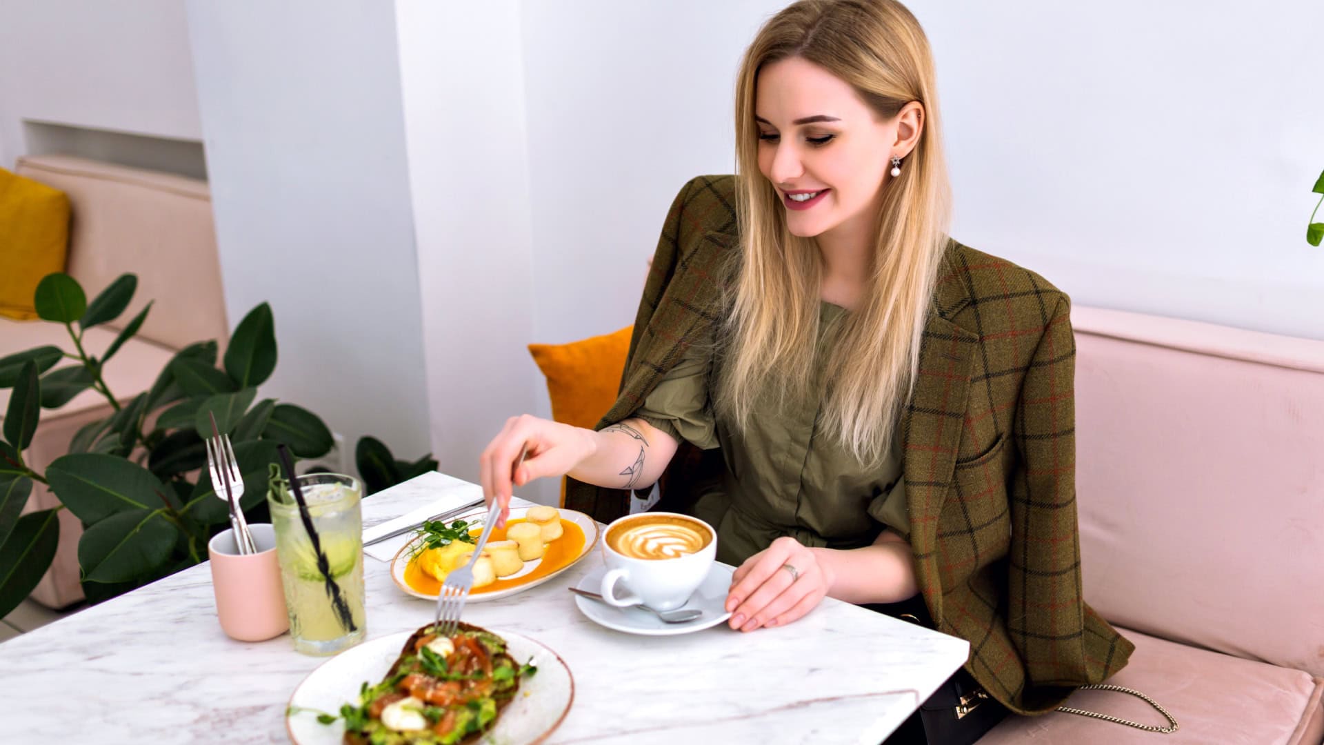 Žena sedí za stolom, na ktorom sú raňajky