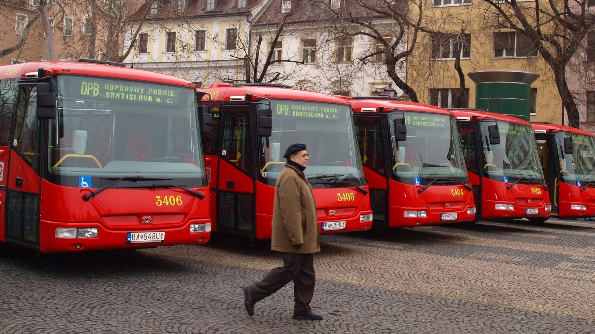 Odparkované autobusy około ktorých prechádza muž.