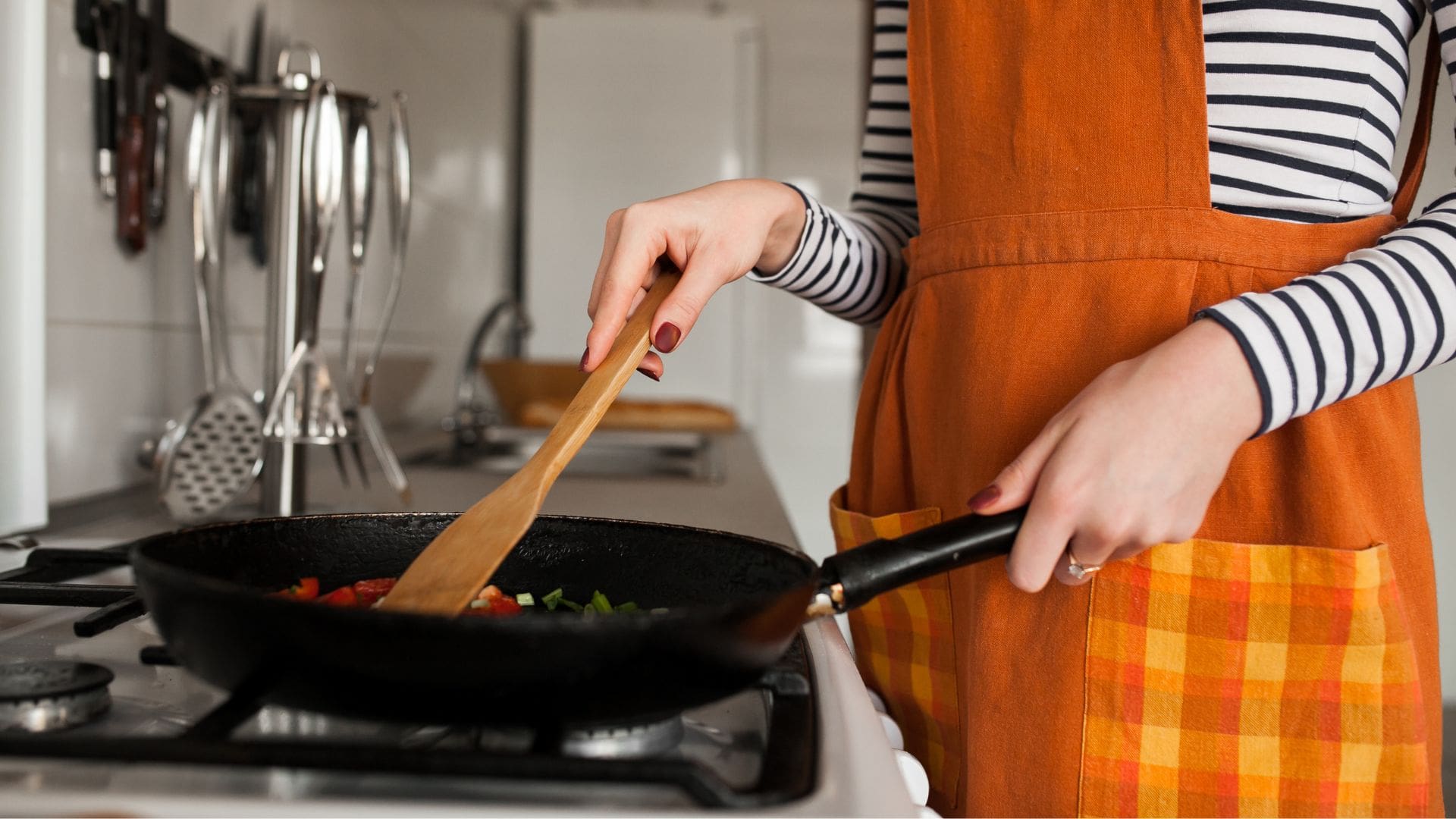 Žena varí jedlo na panvici