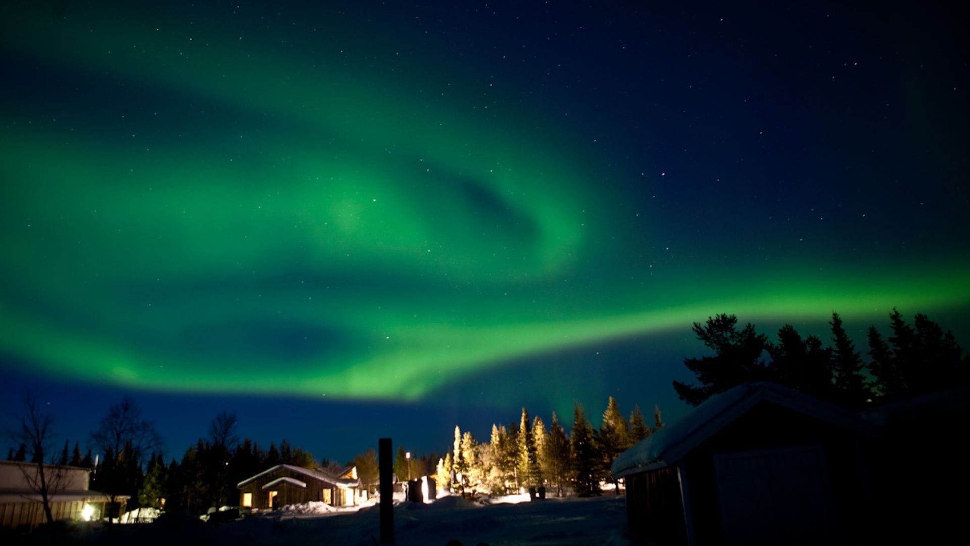 Domy vo Švédsku, nad ktorými je polárna žiara.