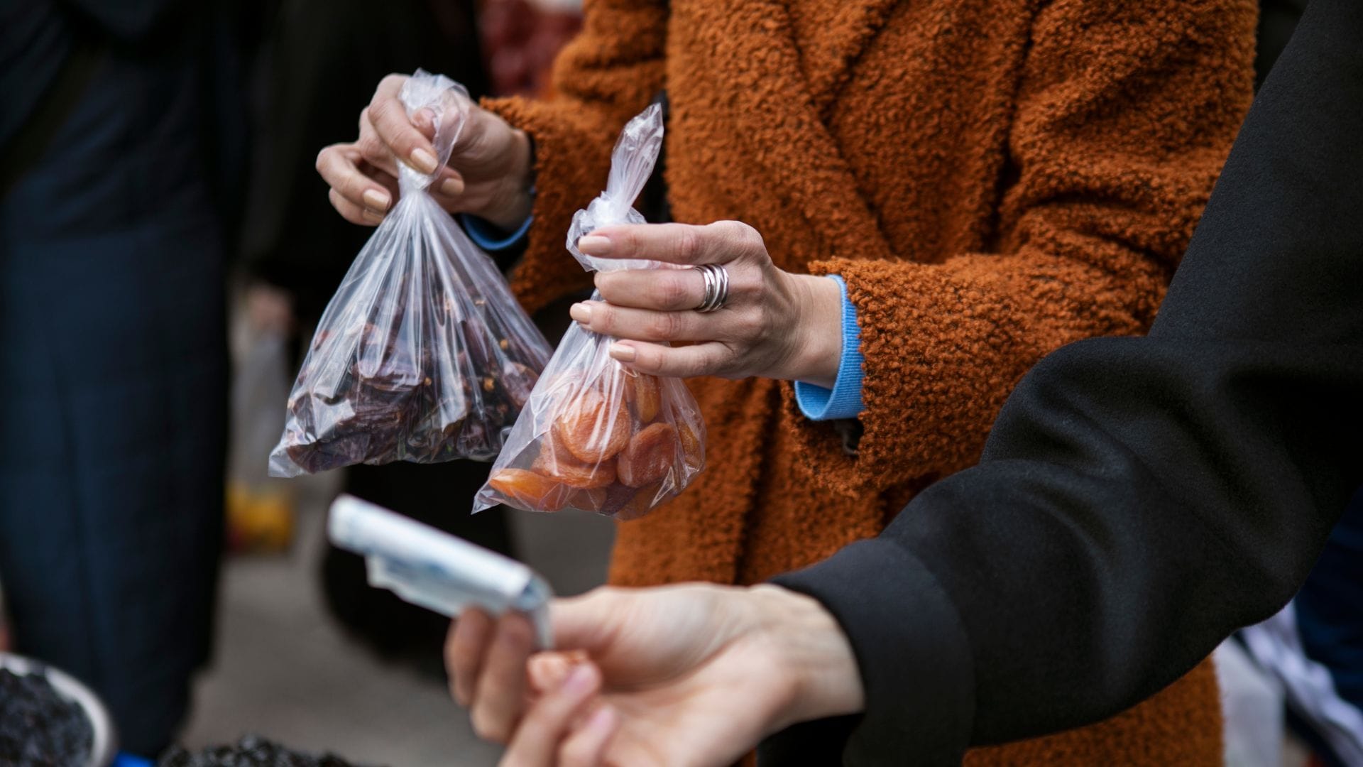 Žena drží mikroténové vrecká, v ktorých je sušené ovocie
