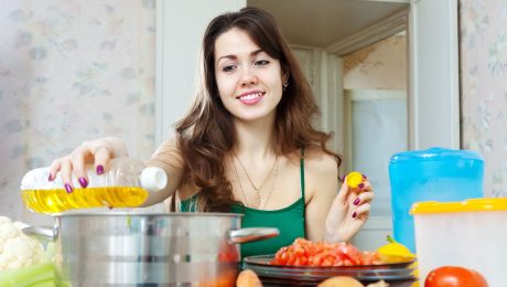 Žena dáva olej do hrnca