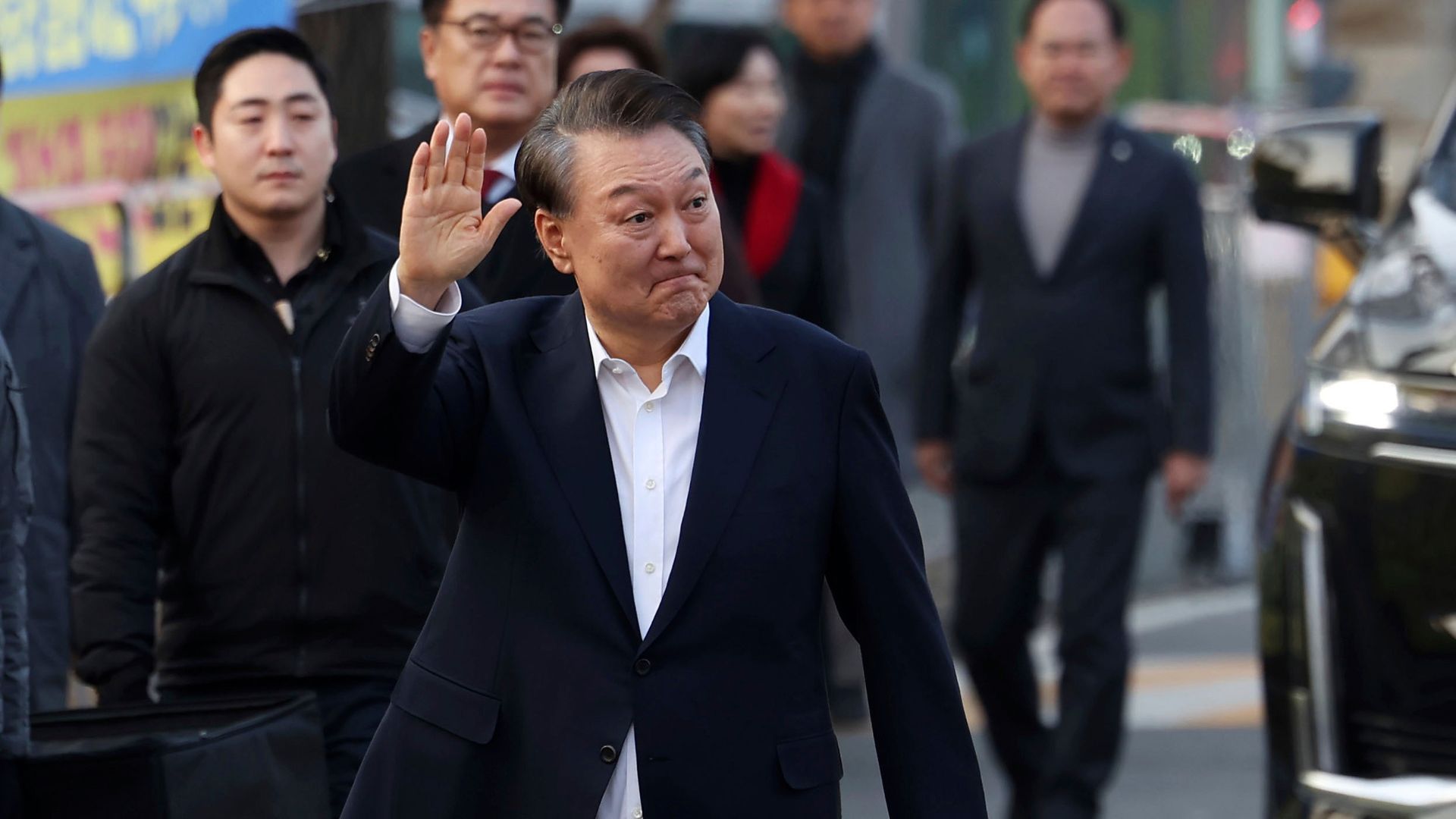 Na archívnej snímke z 8. marca 2025 suspendovaný juhokórejský prezident Jun Sok-jol máva svojim priaznivcom pri odchode z väzenského centra v juhokórejskom meste Uiwang.