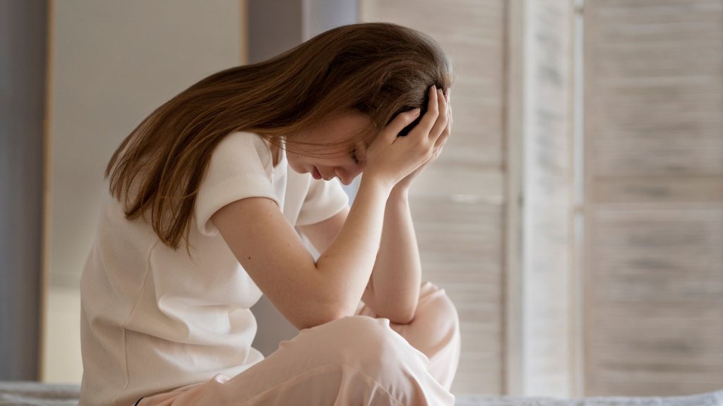 mladá žena smúti, depresia, rakovina