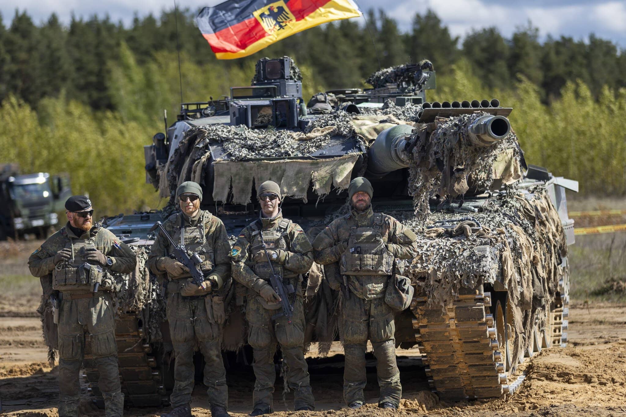 Nemeckí vojaci stoja pred hlavným bojovým tankom Loepard 2A6 počas vojenského cvičenia „Iron Wolf 2025-I“ vo výcvikovom priestore Gaiziunai, približne 130 km západne od hlavného mesta Vilnius v Litve