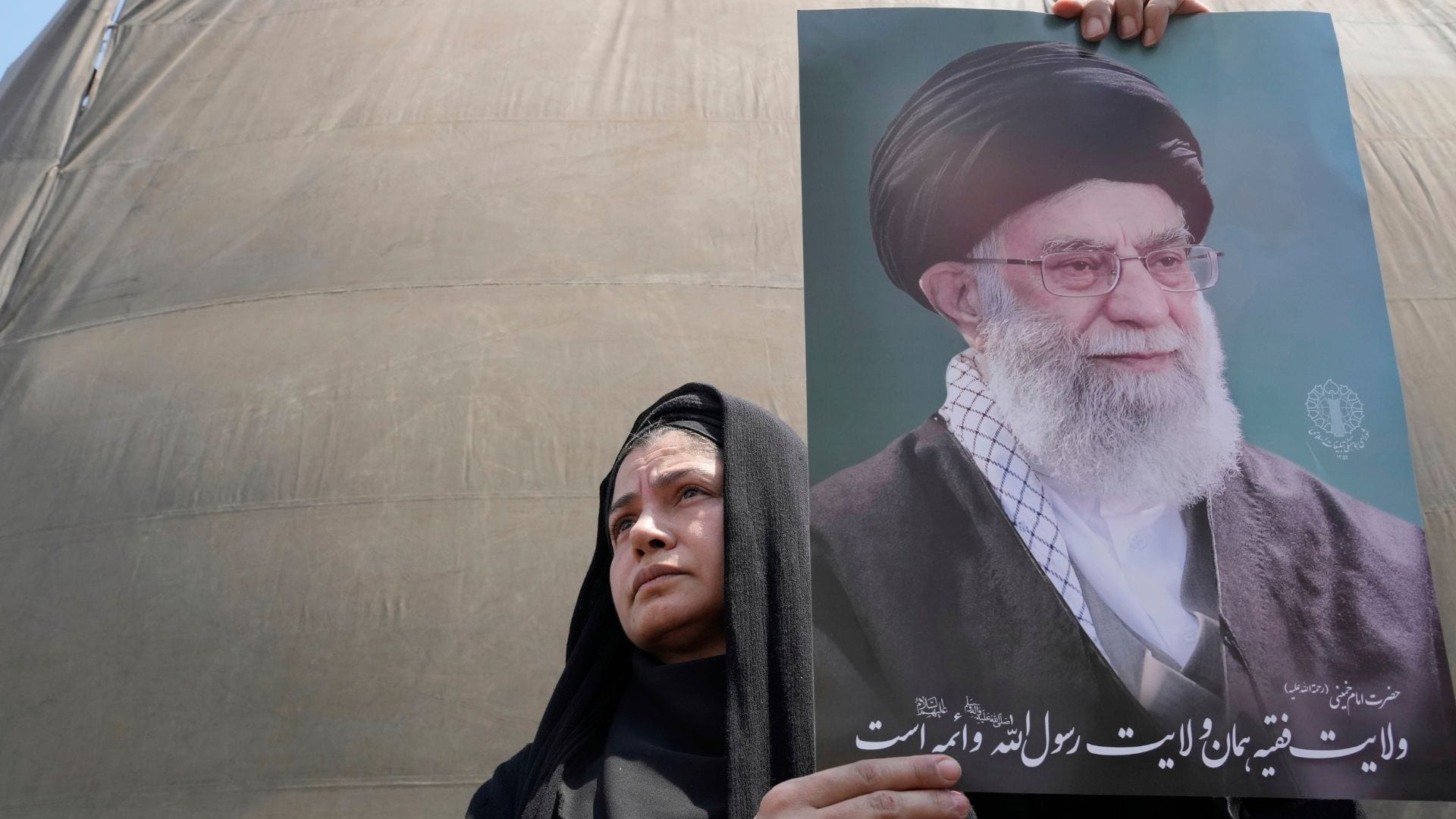 Iránka drží plagát s podobizňou najvyššieho iránskeho duchovného vodcu ajatolláha Alího Chameneího