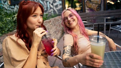 Dve mladé ženy, jedna pije smoothie z červenej repy