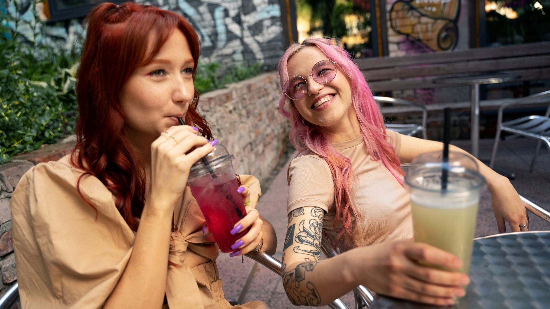 Dve mladé ženy, jedna pije smoothie z červenej repy