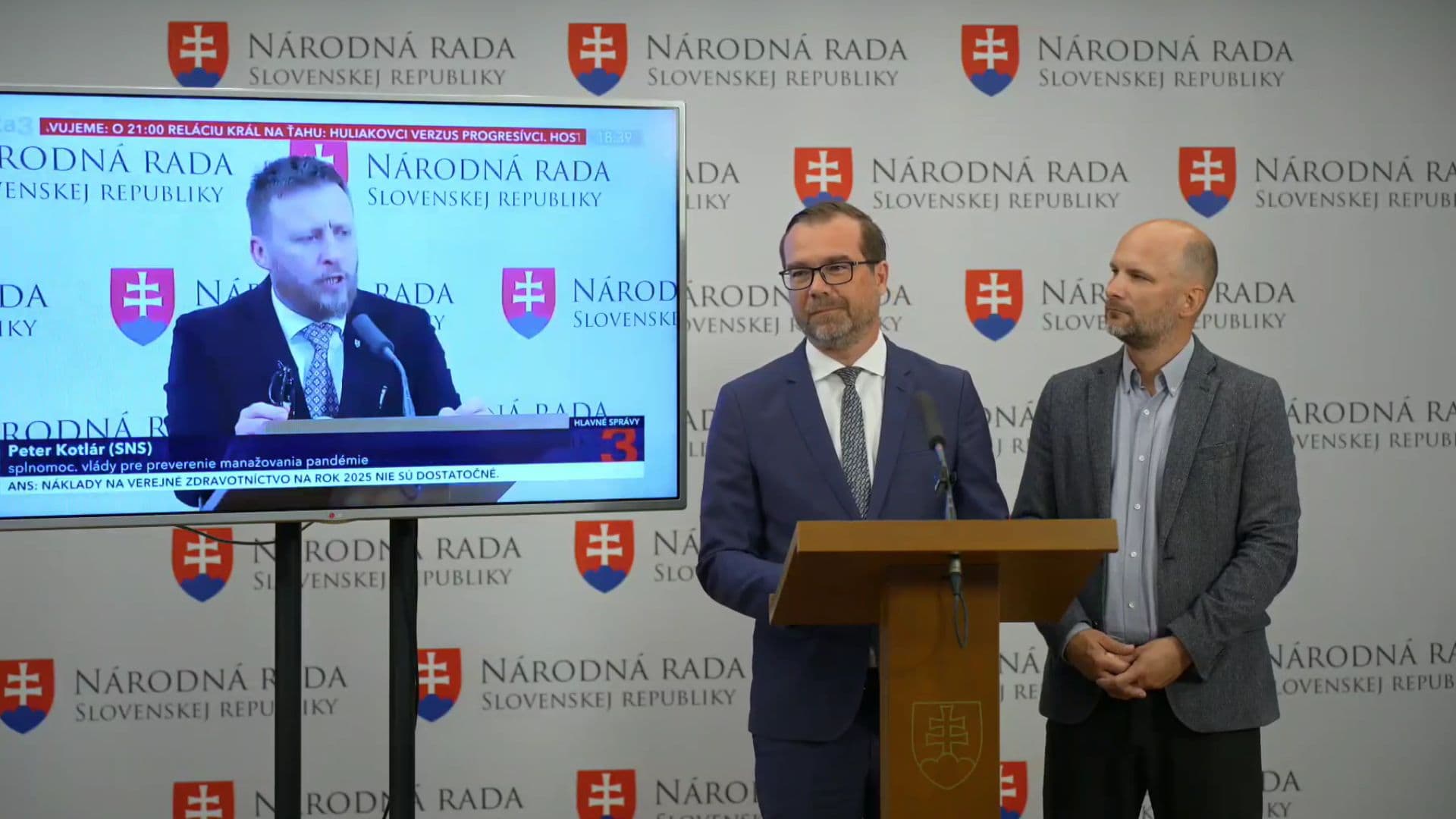 Na snímke exminister Marek Krajčí a poslanec Gábor Grendel v pozadí na obrazovke s Petrom Kotlárom.