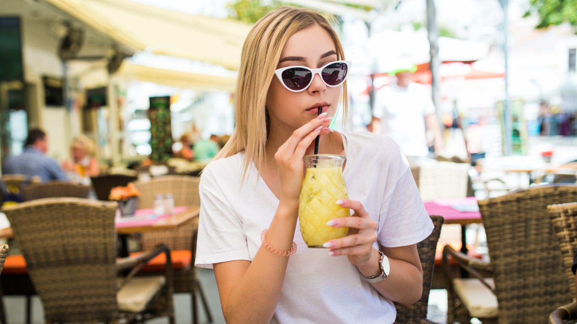 Žena sedí v kaviarni a pije nápoj s umelým sladidlom