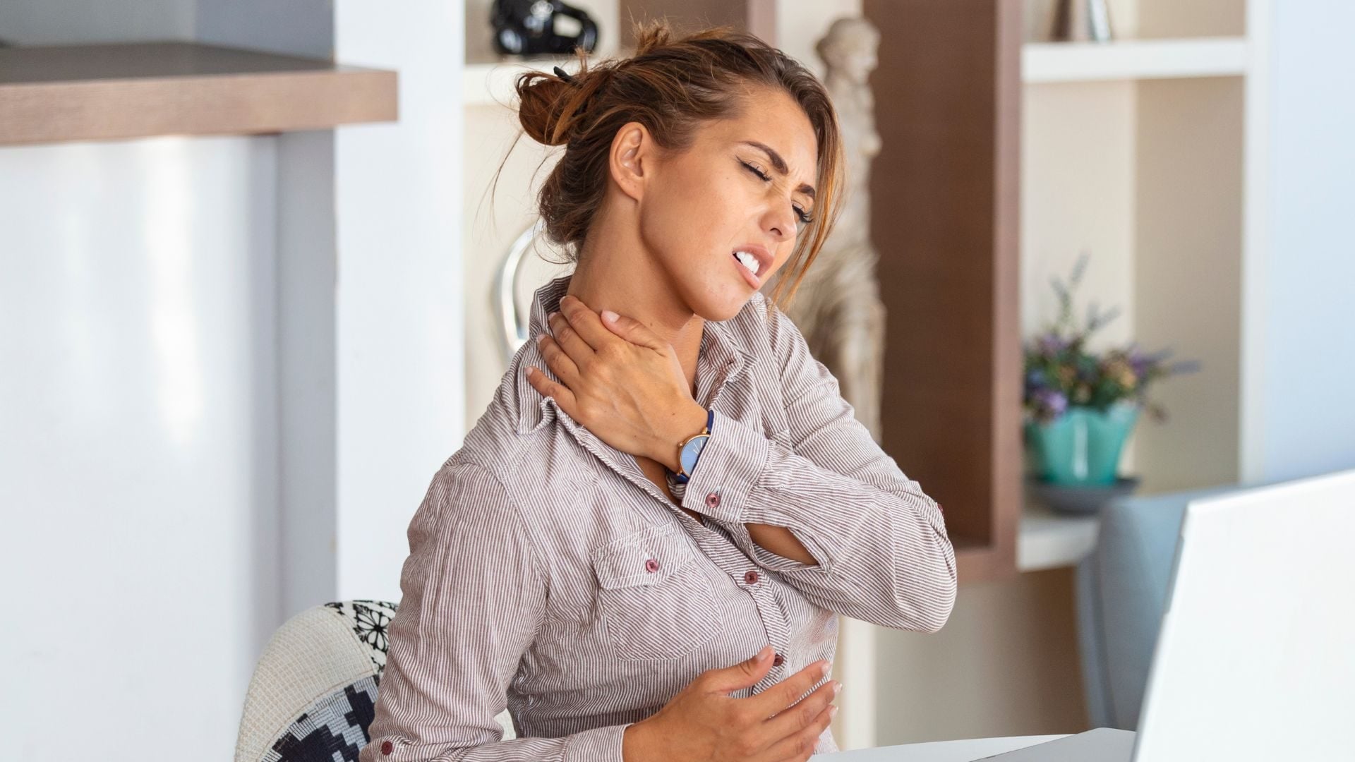 Žena sedí za notebookom a má bolesti, infarkt