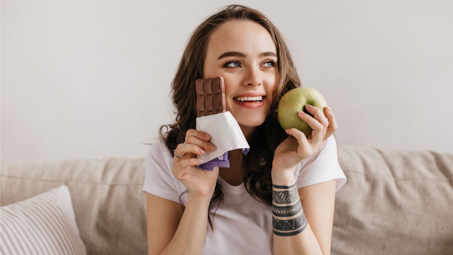 Žena má v ruke čokoládu a jablko