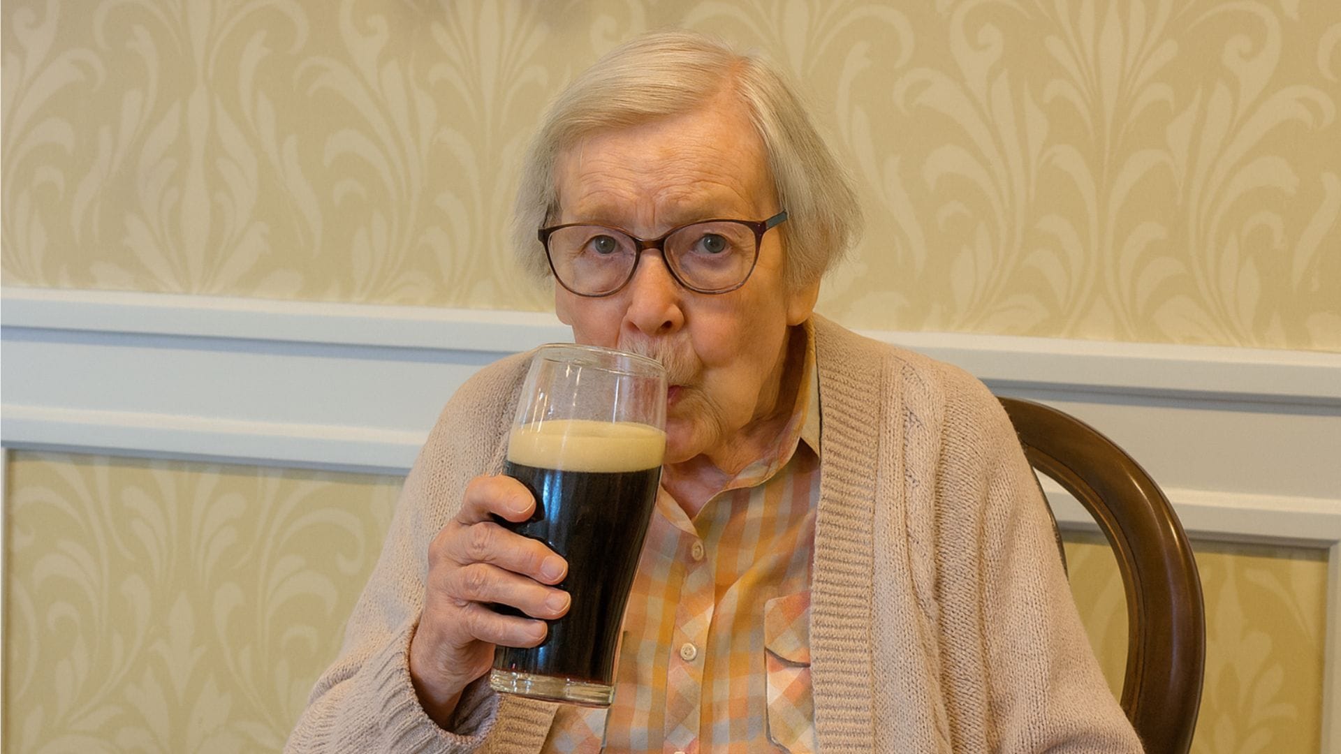 Staršia žena pije pivo